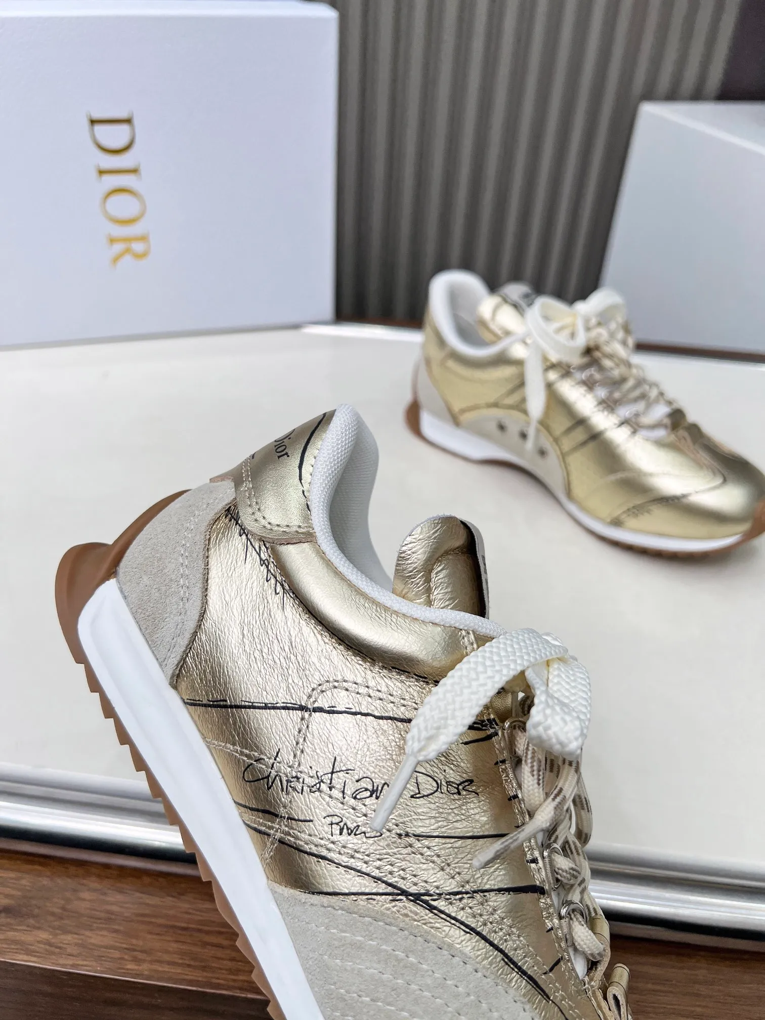 👟👟Ex-factory price 560👟👟 This D-Sketch sneaker is a new product of the 2025 spring and summer ready-to-wear series, highlighting the classic retro aesthetics. Crafted from gold-tone crinkled sheepskin and gold-toned laminated calfskin, it features a printed logo inspired by the shoe's production stages, as well as beige suede calfskin panels and double laces. Hand-written Christian Dior Paris signature on the side, Christian Dior Paris signature panels and plaques on the heel and tongue. Paired with two-tone slim rubber soles, they add a touch of couture to any casual look. Code number: 35~45 Color: black white gold silver